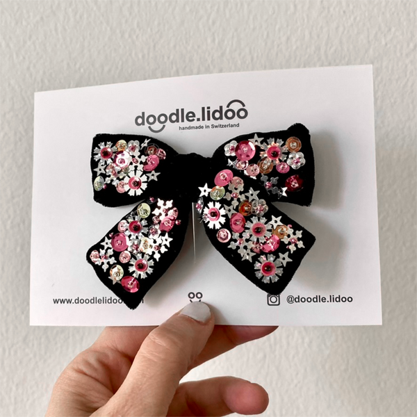 Medium black velvet hair bow with sequins mounted onto a hair clip.