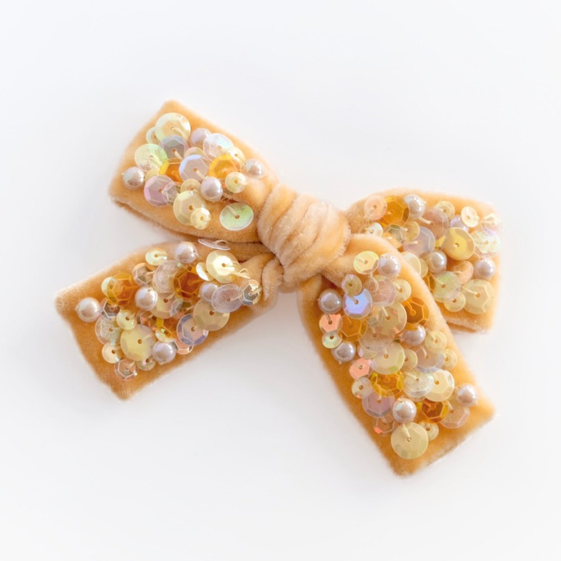 Velvet hair bow embellished with sequins and pearl beads in yellow color tones.