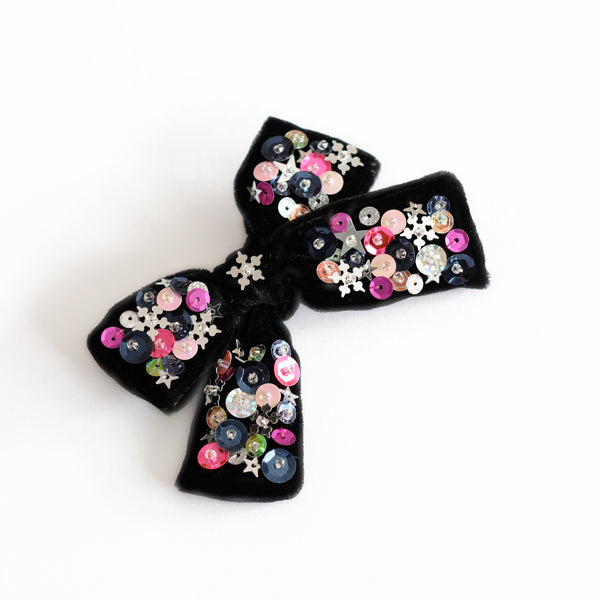 Black velvet hair bow embellished with fun silver, pink and black colored round and star shaped sequin and perals.