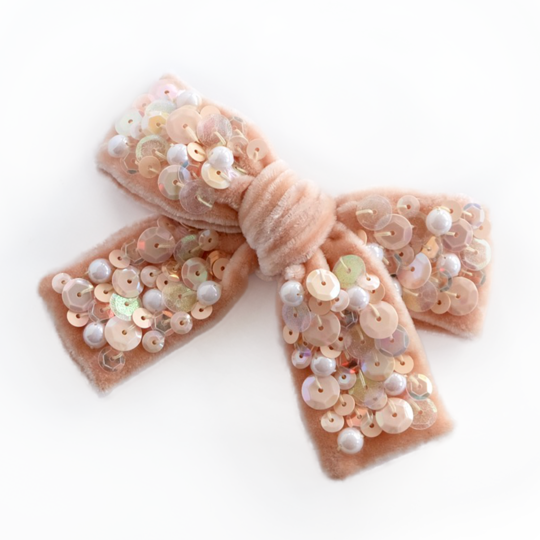 Peach colored hair bow made from velvet and embellished with sequins and pearls.