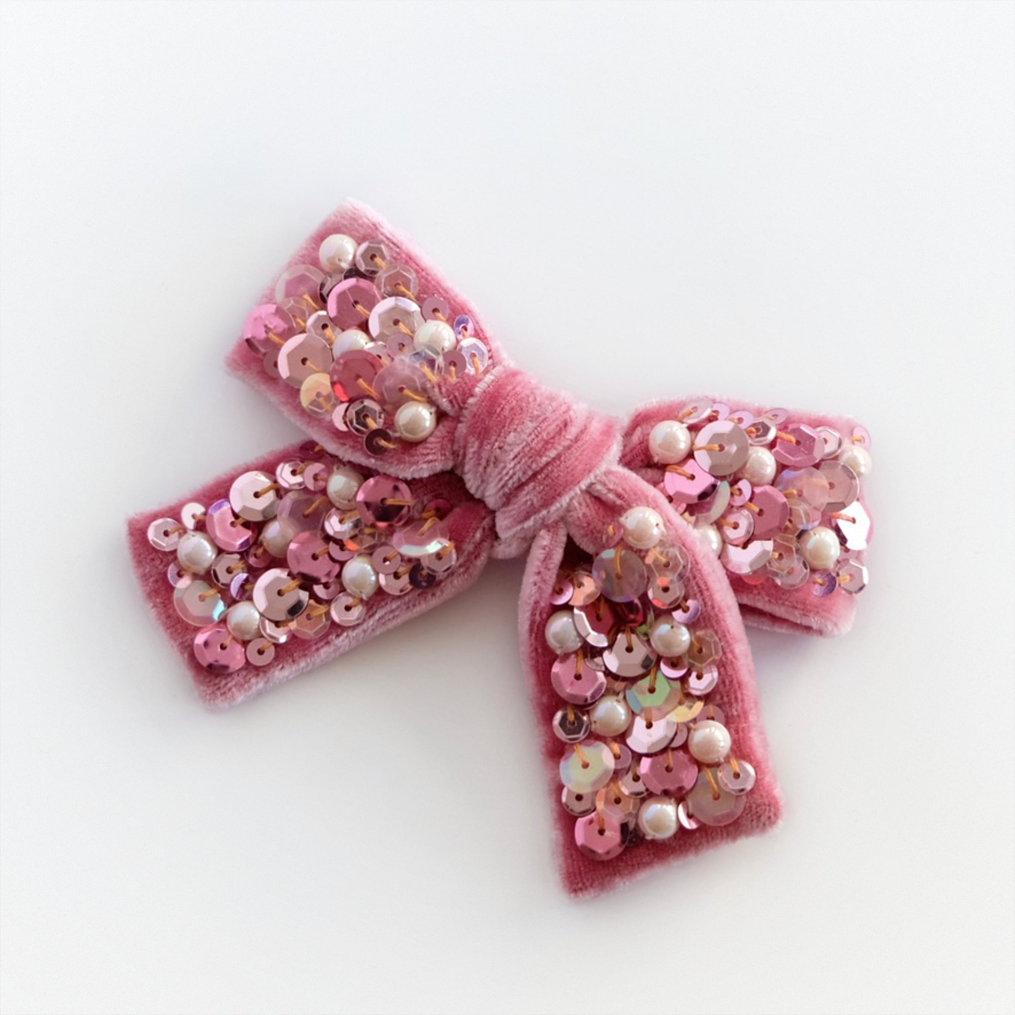 Velvet hair bow for girls in pink embellished with sequin and pearls.