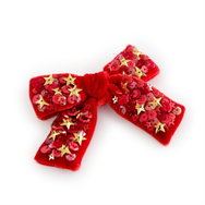 A star studded hair bow made from from luxurious red velvet and embellished with with gold stars and sequins.