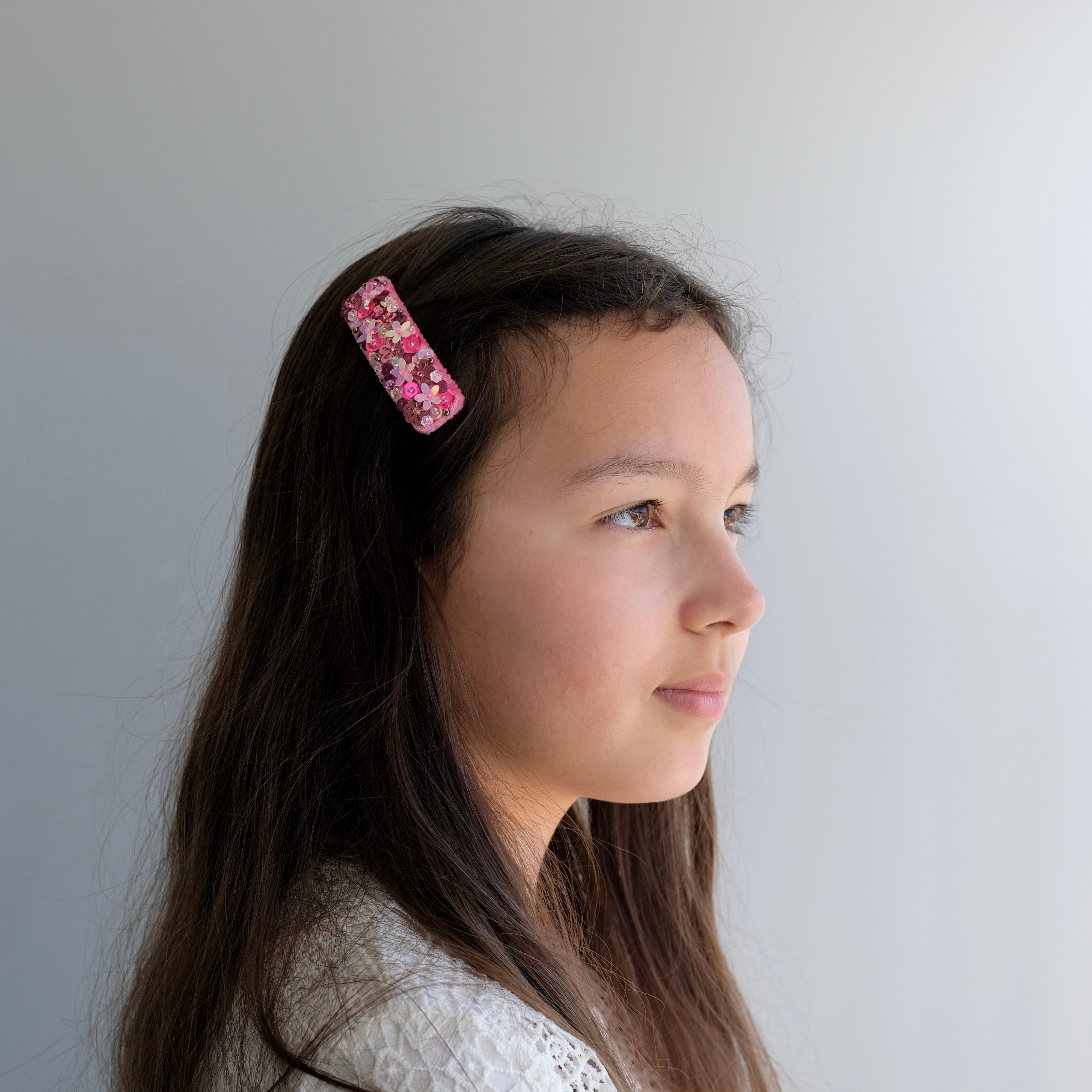 Girl wearing our striking sequin snap clip in bright pink.