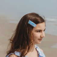 Large velvet hair clip with sequin worn by a teenage girl.