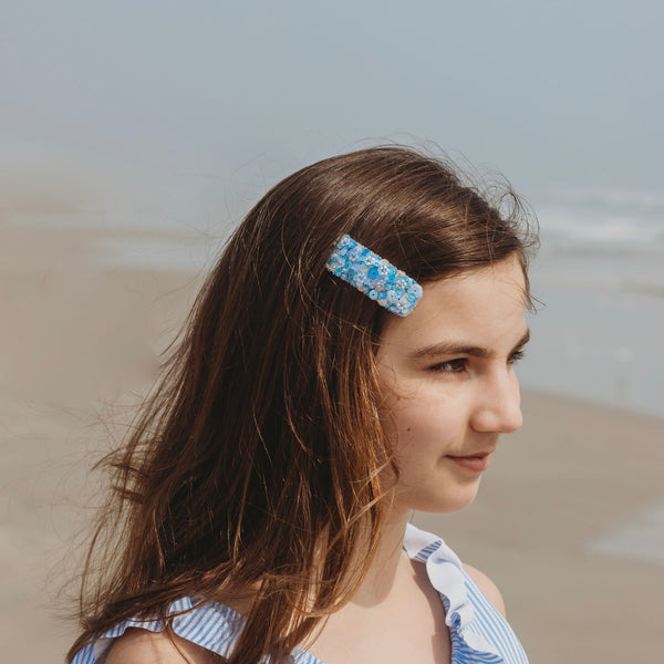Girl on the beach wearing our Skye hair clip.