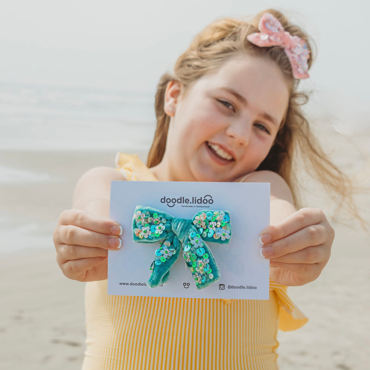 Girl in her tweens holding a medium size sequin hair bow by doodlelidoo.