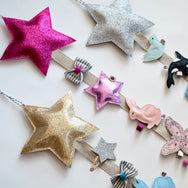 Handmade hair clip holder with large star feature are available in silver, gold, pink, and blue.