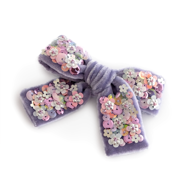 Lavender velvet hair bow embellished with round and flower shaped sequins in lilac, white and silver.