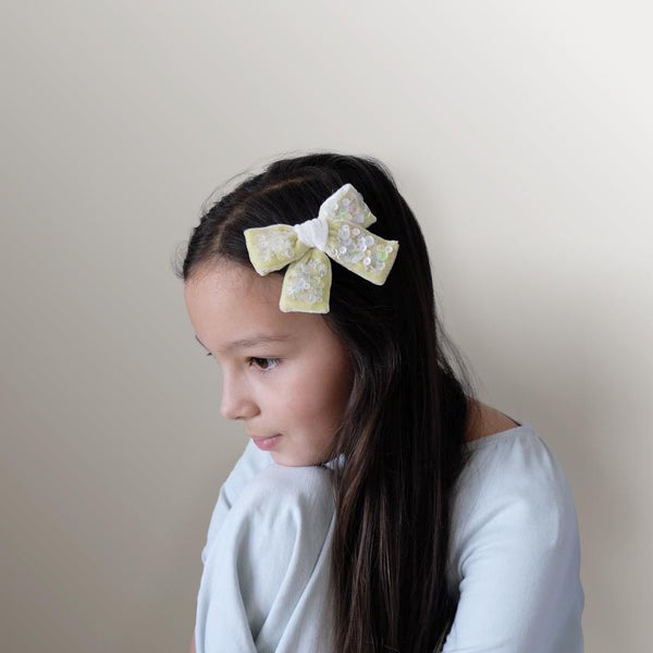 Model with pale yellow bow embellished with sequin.