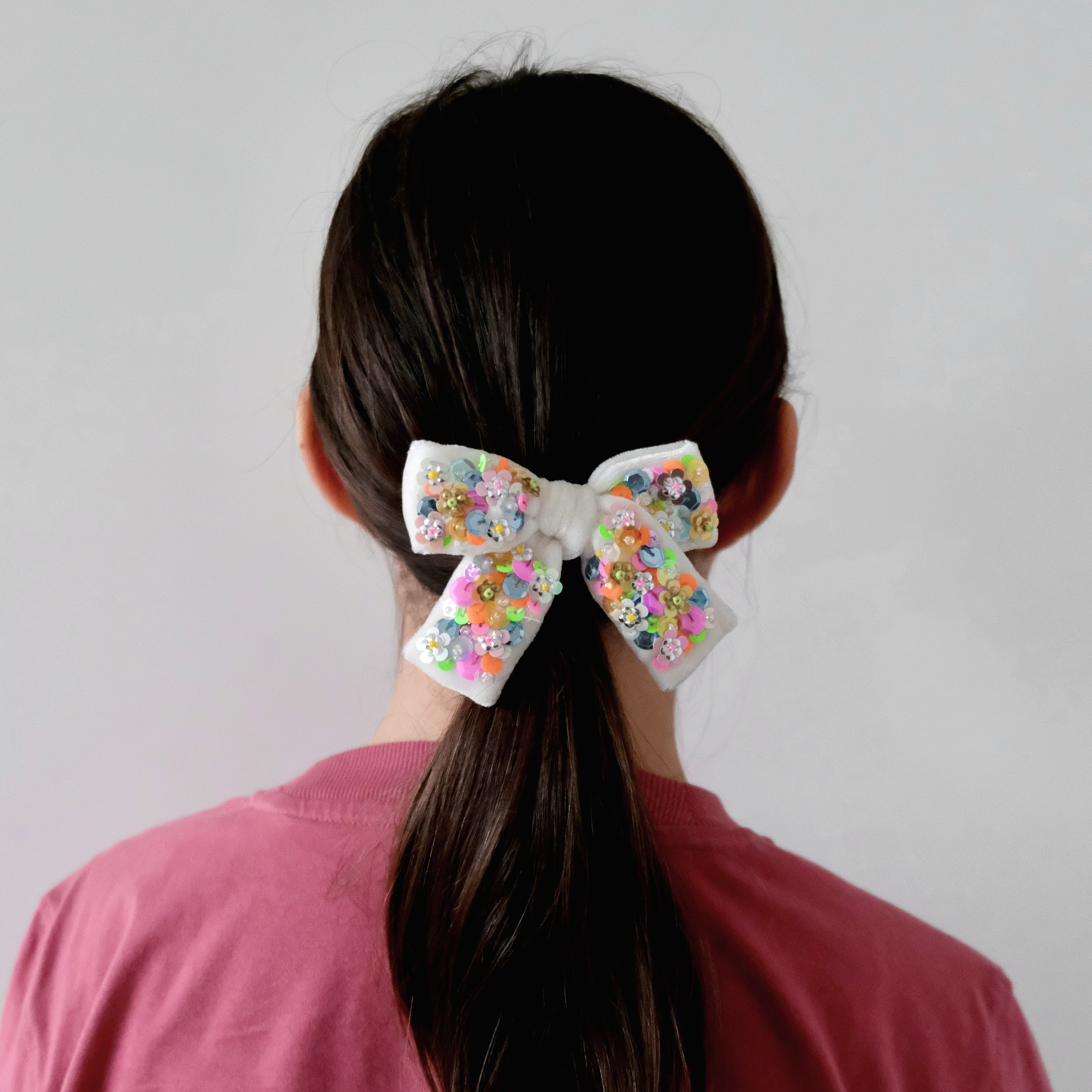 Neon velvet hair bow, in mediums size, worn on  a pony tail.