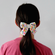 Neon velvet hair bow, in mediums size, worn on  a pony tail.
