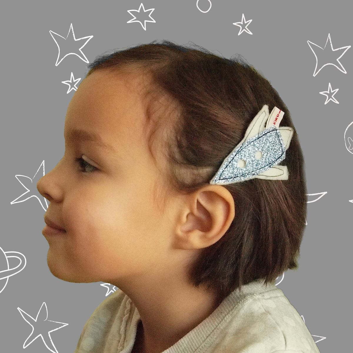 Little space explorer with her cute spaceship hair clip, made by doodlelidoo.